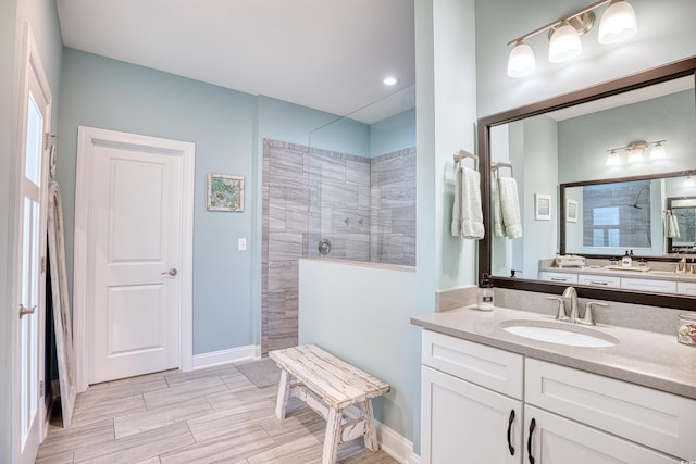 bathroom featuring a tile shower and vanity