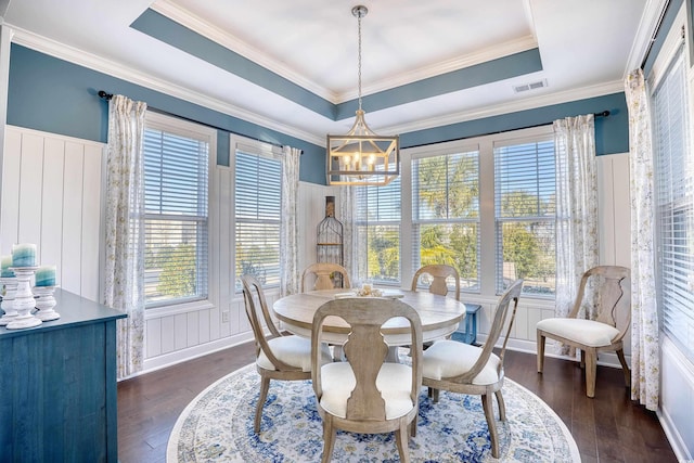 dining space with a notable chandelier, dark hardwood / wood-style floors, a healthy amount of sunlight, and a tray ceiling