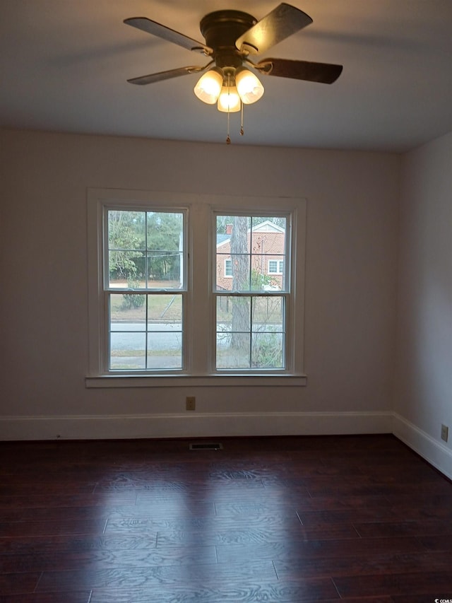 unfurnished room with ceiling fan and dark wood-type flooring