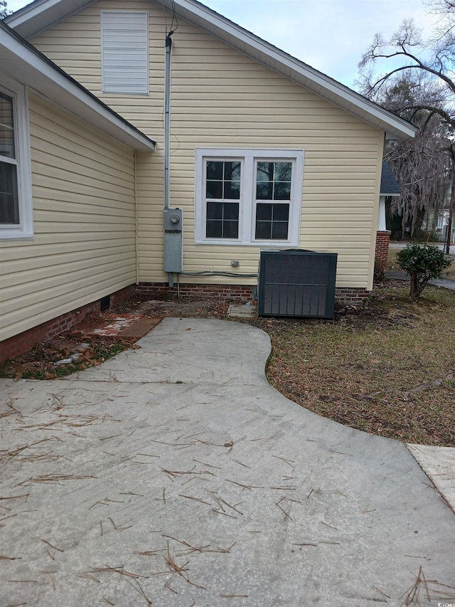 view of side of home with a patio and central AC