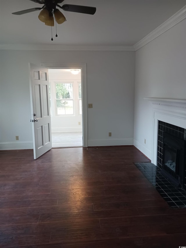 unfurnished living room featuring ornamental molding, dark hardwood / wood-style flooring, a tile fireplace, and ceiling fan