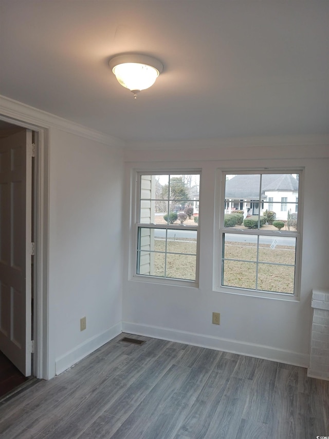 empty room featuring crown molding and dark hardwood / wood-style floors