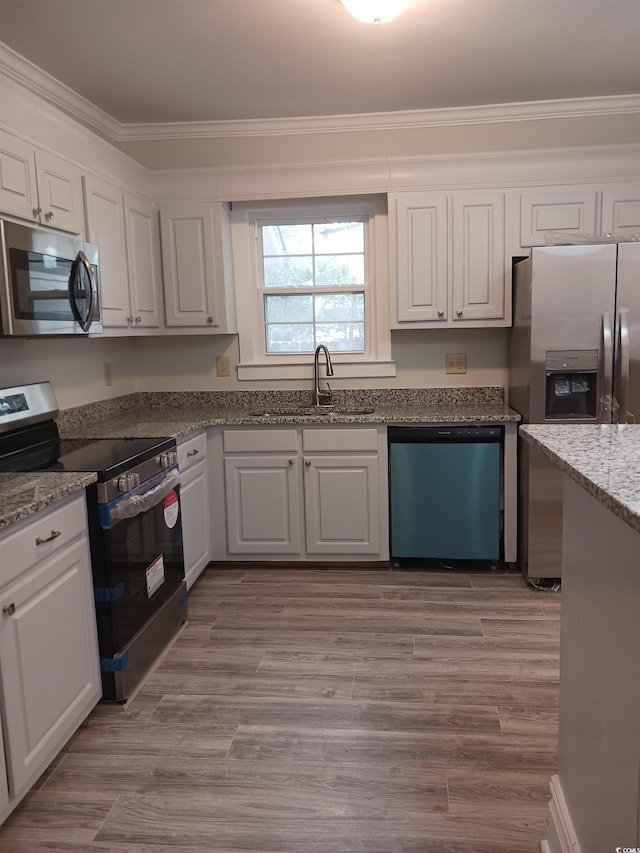 kitchen featuring stainless steel appliances, white cabinetry, and sink