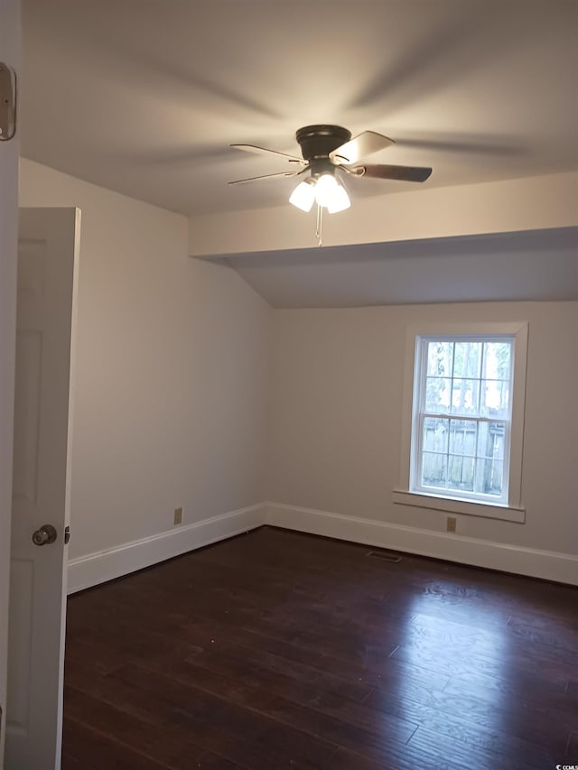 unfurnished room featuring ceiling fan, dark hardwood / wood-style flooring, and vaulted ceiling