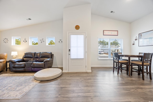 living room featuring dark hardwood / wood-style flooring and high vaulted ceiling