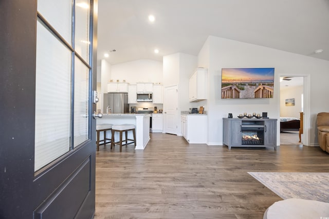 living room with hardwood / wood-style floors and vaulted ceiling