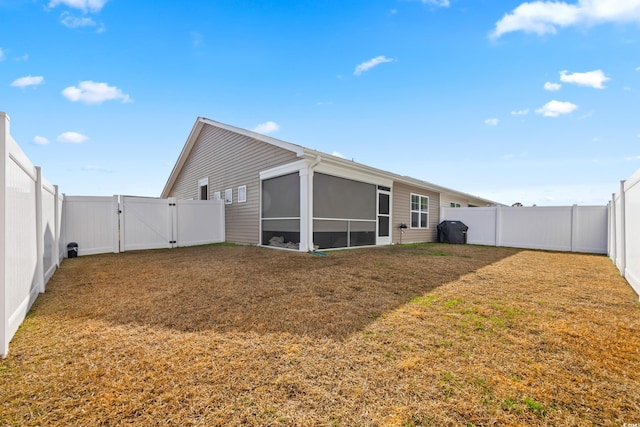 back of house with a yard and a sunroom