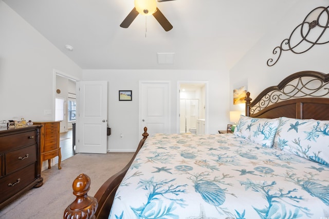 bedroom featuring ceiling fan, light carpet, connected bathroom, and vaulted ceiling