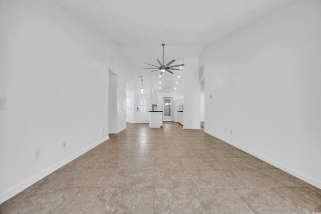 unfurnished living room with high vaulted ceiling and ceiling fan