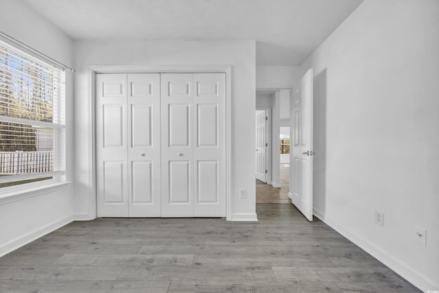 unfurnished bedroom featuring light hardwood / wood-style floors and a closet