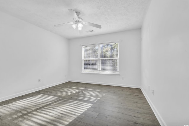 empty room with a textured ceiling, dark hardwood / wood-style flooring, and ceiling fan