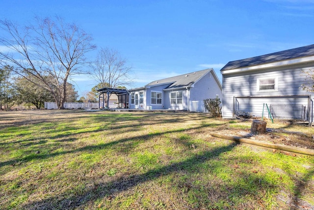 back of house with a pergola and a lawn