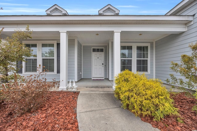 view of exterior entry featuring covered porch