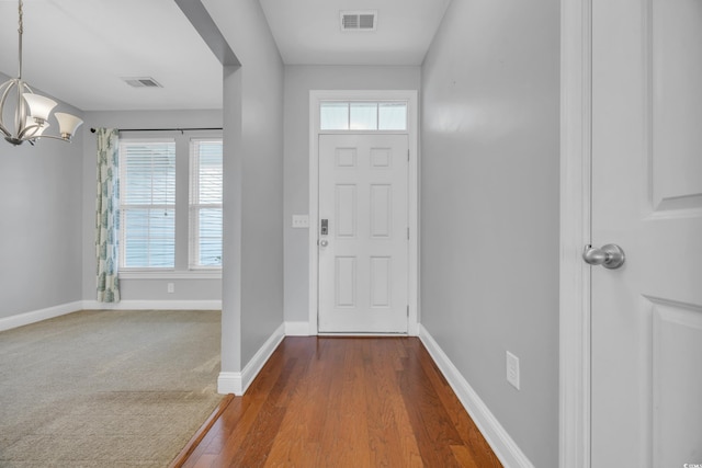 foyer entrance featuring hardwood / wood-style flooring and an inviting chandelier