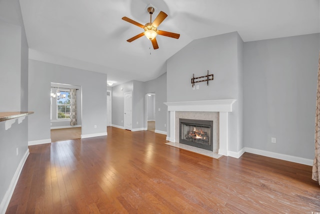 unfurnished living room with ceiling fan with notable chandelier, hardwood / wood-style flooring, and lofted ceiling