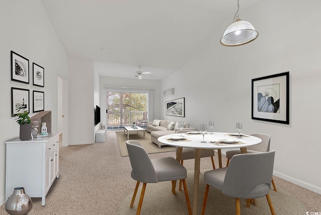 dining space with light carpet and ceiling fan