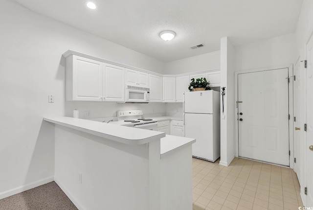 kitchen with white appliances, white cabinets, a textured ceiling, and kitchen peninsula