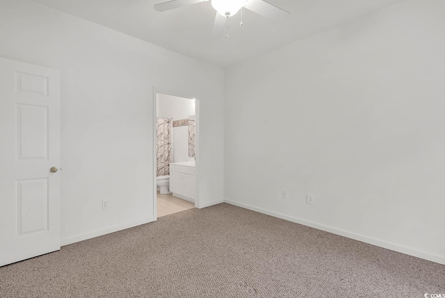 unfurnished bedroom featuring ceiling fan, connected bathroom, and light colored carpet