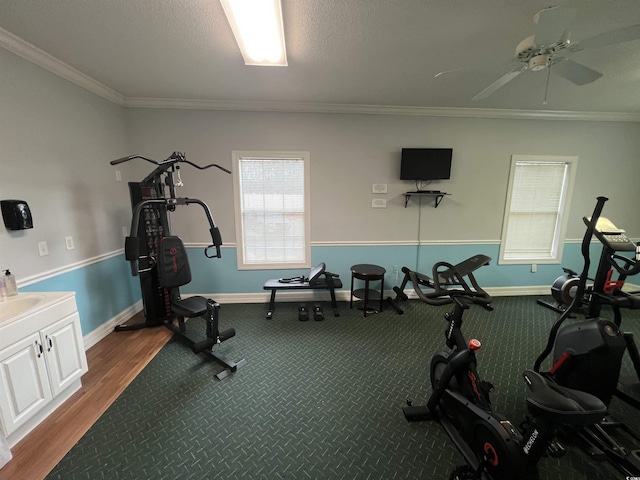 workout area featuring a textured ceiling, hardwood / wood-style flooring, crown molding, and ceiling fan