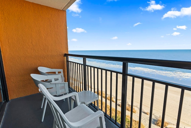 balcony featuring a beach view and a water view