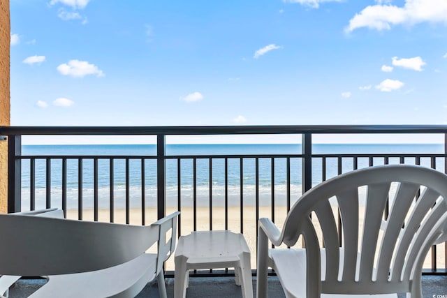 balcony featuring a water view and a beach view