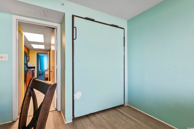 interior space with a textured ceiling and wood-type flooring