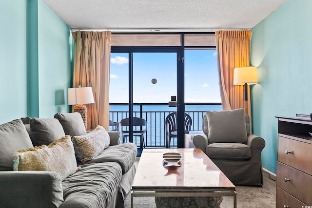 living room featuring a textured ceiling, a water view, and expansive windows