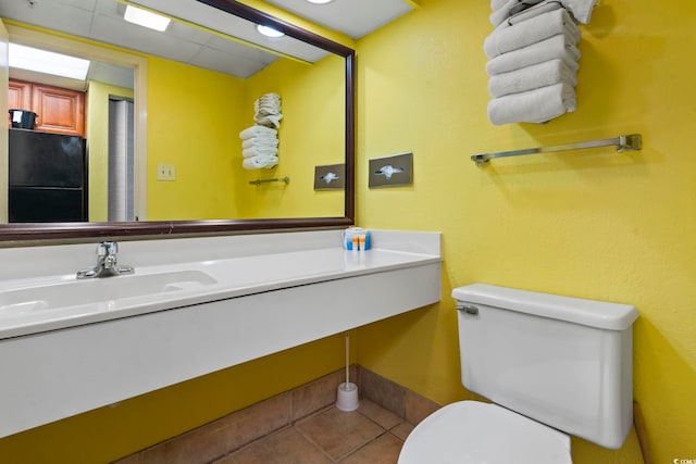 bathroom featuring toilet, tile patterned floors, and sink