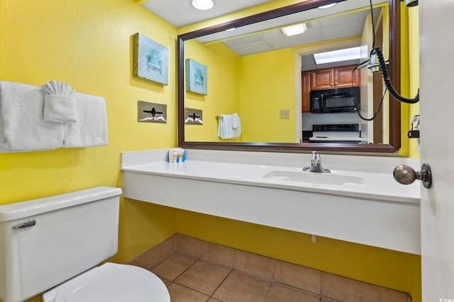 bathroom featuring toilet, tile patterned floors, and sink