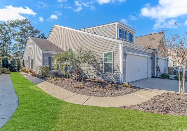 view of side of property with a garage, concrete driveway, and a lawn