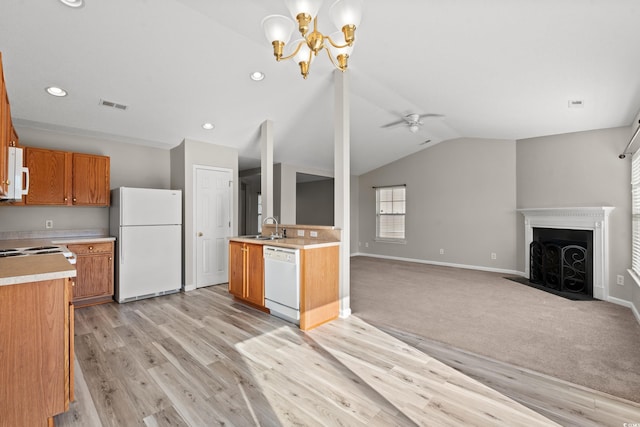 kitchen with lofted ceiling, white appliances, ceiling fan with notable chandelier, sink, and light hardwood / wood-style floors