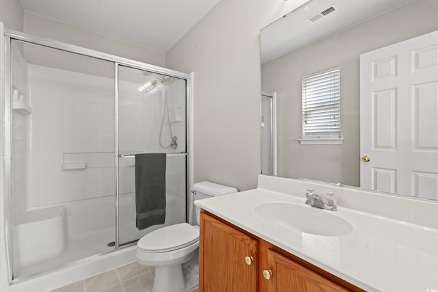 bathroom with tile patterned flooring, vanity, toilet, and a shower with door