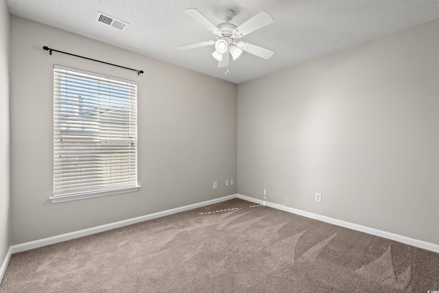 unfurnished room with carpet flooring, ceiling fan, and a textured ceiling