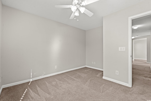 carpeted spare room featuring ceiling fan