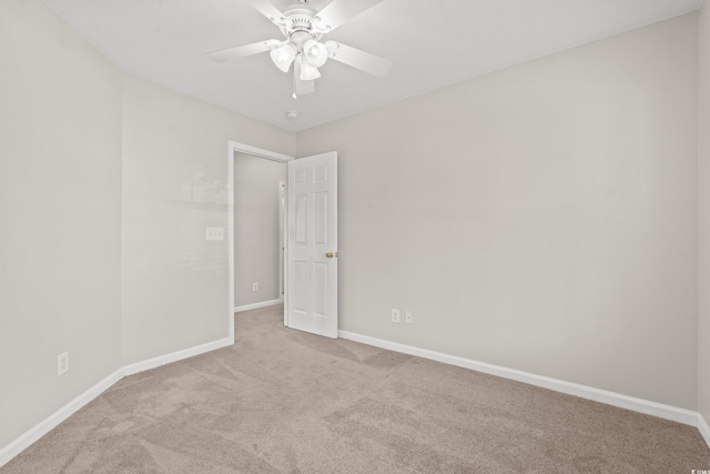 empty room featuring ceiling fan and light colored carpet