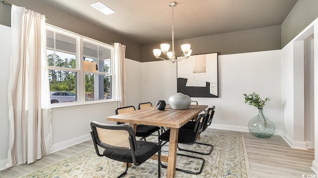 dining area featuring a chandelier, baseboards, and light wood-style floors
