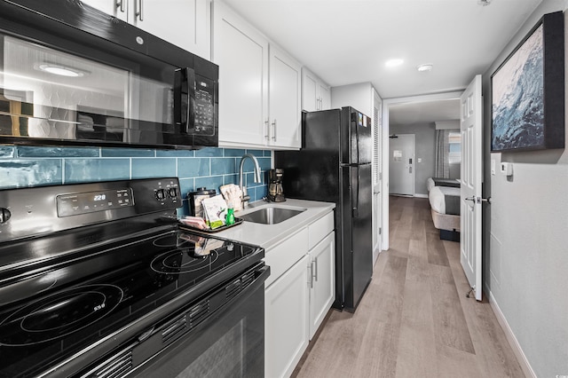 2006 N Ocean Blvd Unit 776, Myrtle Beach, SC 29577 - kitchen featuring black appliances, a sink, light wood finished floors, decorative backsplash, and white cabinetry