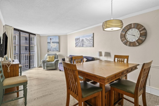 dining space with a textured ceiling, crown molding, and hardwood / wood-style flooring