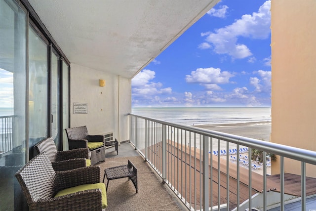 balcony featuring a beach view and a water view