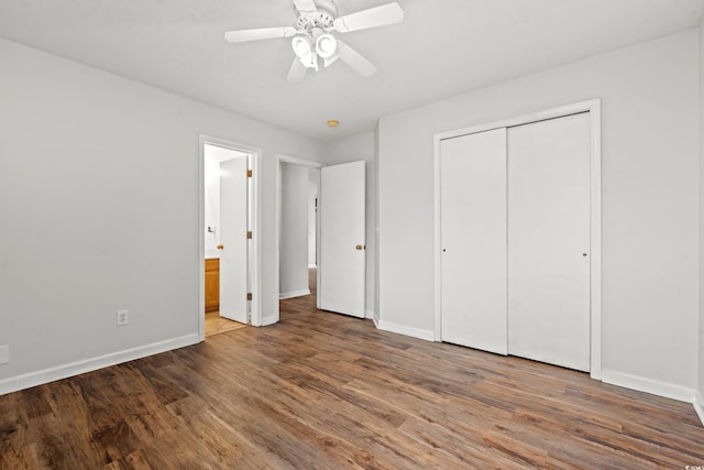 unfurnished bedroom with wood-type flooring, a closet, ensuite bath, and ceiling fan