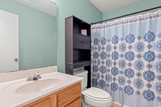 bathroom with vanity, curtained shower, toilet, and a textured ceiling