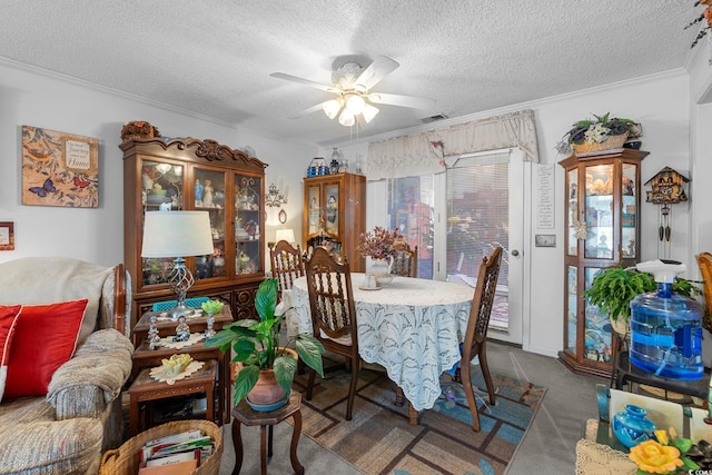 carpeted dining room with a textured ceiling, ceiling fan, and crown molding