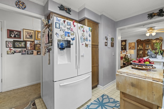 kitchen featuring crown molding, ceiling fan, white fridge with ice dispenser, a textured ceiling, and light tile patterned floors