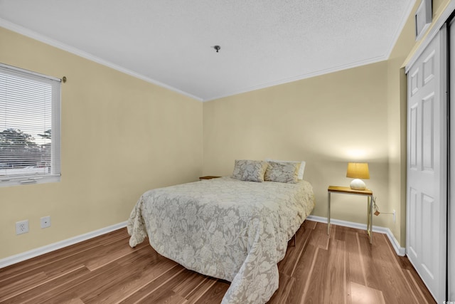 bedroom featuring a closet, hardwood / wood-style floors, and crown molding