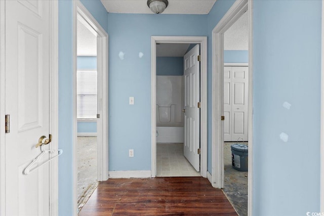 hallway featuring a textured ceiling and dark hardwood / wood-style floors