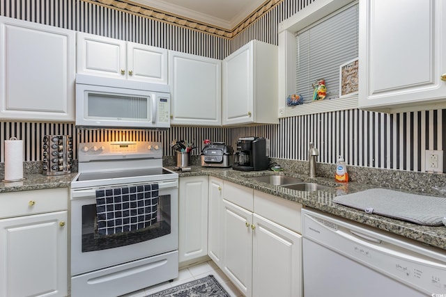 kitchen with white appliances, white cabinetry, and sink