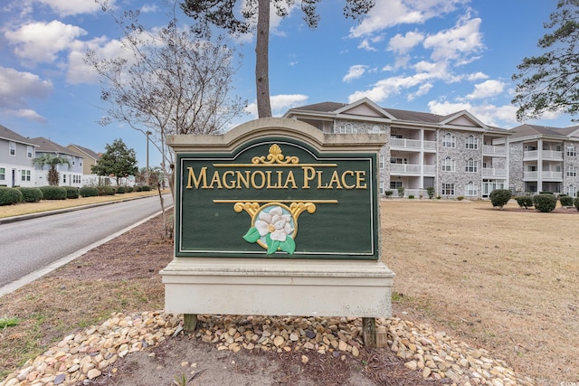 community / neighborhood sign featuring a yard