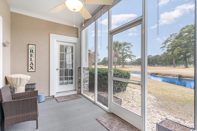 sunroom with a water view and ceiling fan