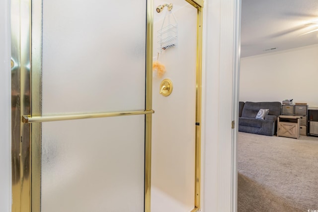 bathroom featuring crown molding and a shower with door