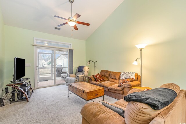 carpeted living room with ceiling fan and high vaulted ceiling